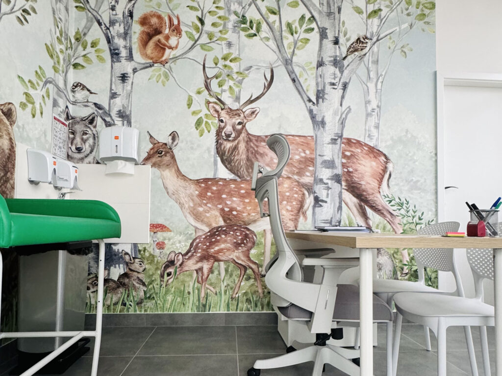wnętrze gabinetu pediatry z kolorową tapetą na ścianie